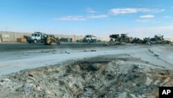 FILE - In this Jan. 13, 2020 file photo, Iranian bombing caused a crater at Ain al-Asad air base in Anbar, Iraq.