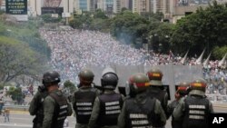 FILE - Venezuelan National Guard members watch anti-government marchers trying to make their way to the National Assembly in Caracas, Venezuela, May 3, 2017.