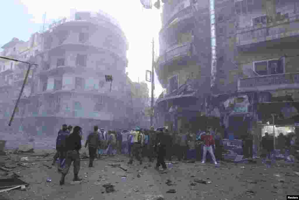 Civilians and Free Syrian Army fighters gather at a site hit by a missile in Aleppo's al-Mashhad district, Syria, January 7, 2013.