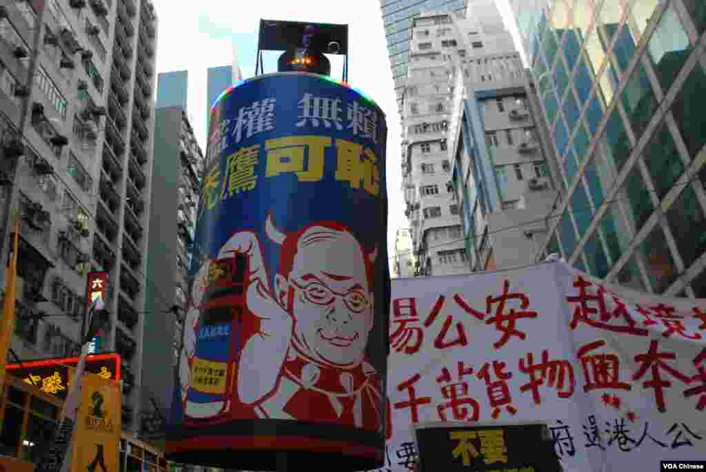 遊行人士高舉仿製的大型胡椒噴霧,抗議香港警權過大