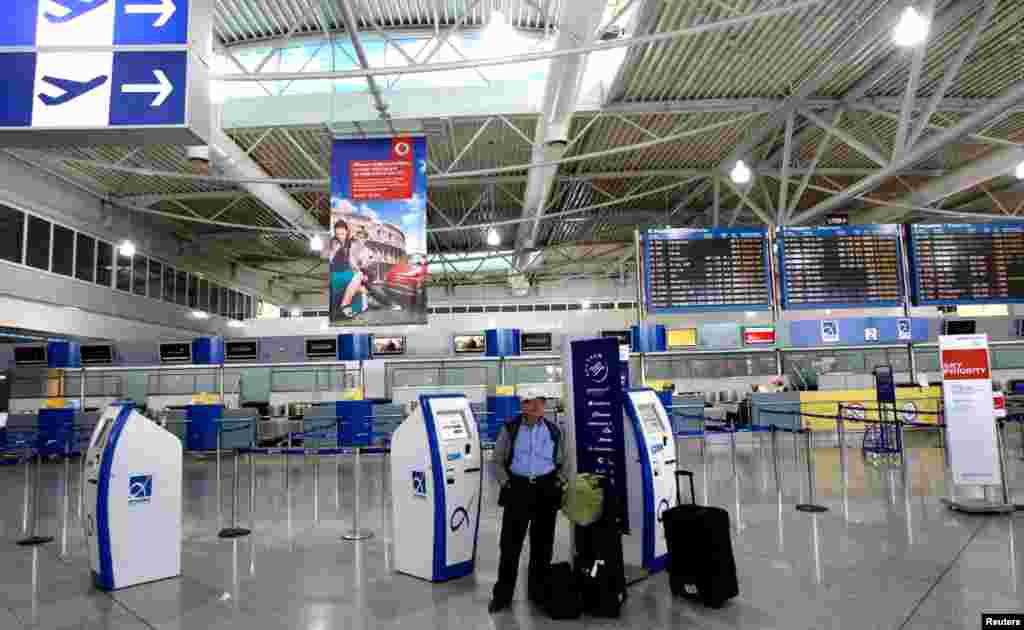 Seorang pria berdiri di tengah-tengah bandara Eleftherios Venizelos yang kosong pada saat berlangsungnya aksi mogok 24 jam di Athena (26/9).