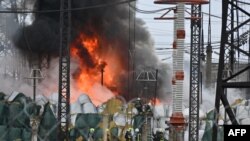 Пожежники гасять пожежу на електропідстанції після ракетного обстрілу в Харкові, 22 березня 2024 року. (Фото: Сергій БОБОК / AFP)