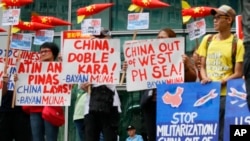 Polisi menjaga pintu masuk ke Konsulat China saat aktivis lingkungan memprotes dugaan pembangunan militer China pada pulau-pulau yang disengketakan di Laut Cina Selatan, 24 Januari 2017 di distrik keuangan Makati timur dari Manila. (AP Photo/Bullit Marquez)