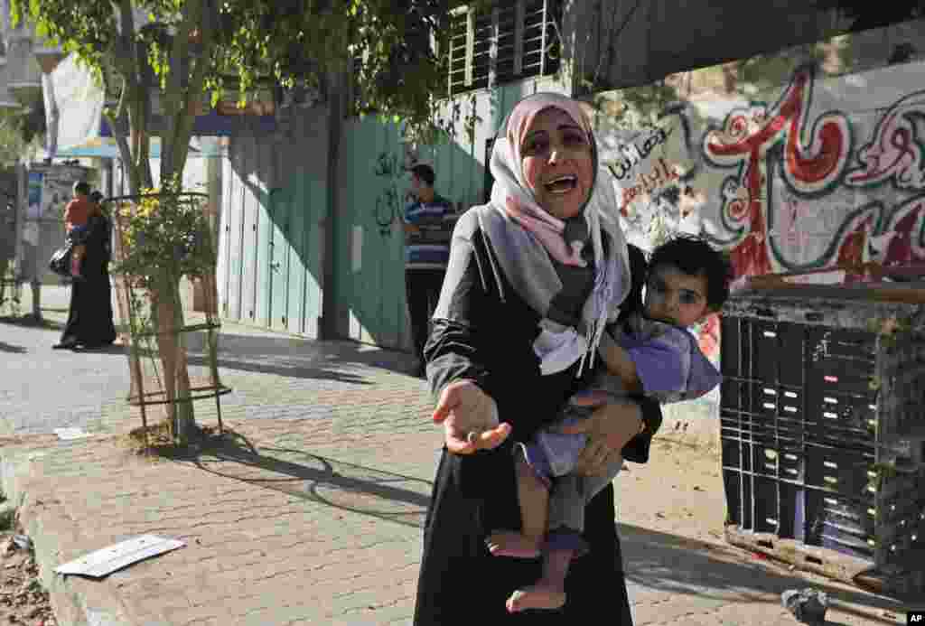Seorang perempuan menangis ketika warga Palestina meninggalkan rumahnya setelah Israel menyebarkan brosur yang disebarkan untuk memperingatkan warga untuk meninggalkan wilayah tersebut di Shajaiyeh, Gaza City, 16 Juli 2014.