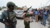 Seorang polisi Kenya tampak mengambil foto warga Haiti di di Port-au-Prince, pada 3 Juli 2024. (Foto: AP/Odelyn Joseph)