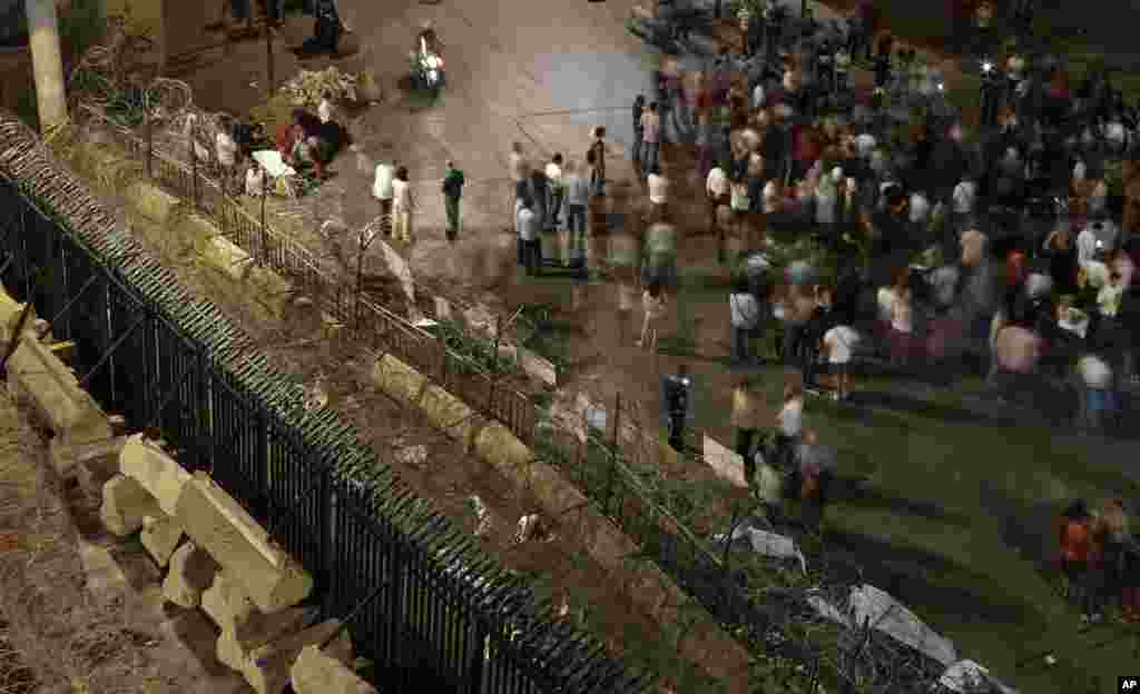 Lebanese anti-government protesters shout slogans as they stand near metal barricades and reinforcements that were installed as extra security measures around the Lebanese government building, in Beirut, Sept. 2, 2015.