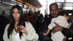 Kanye West beserta istrinya Kim Kardashian dan putri mereka North di bandar udara Los Angeles (8/4). 