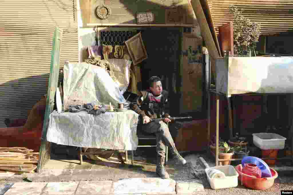 A Free Syrian Army fighter rests with his weapon in the Sheikh Maqsoud neighborhood of Aleppo, Feb. 16, 2014. 