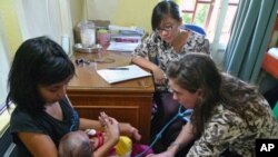 Dr. Kinari Webb listens to a child's chest before diagnosing him with whooping cough at the ASRI clinic in Sukadana, West Kalimantan on August 18, 2011.