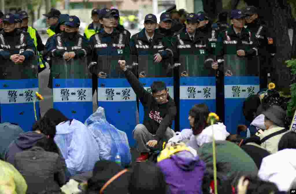 Students protesting against a China Taiwan trade pact rally in front of a wall of police outside of the occupied legislature, in Taipei, Taiwan, March 20, 2014.