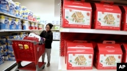 FILE - A shopper looks at an item before placing it in her cart during a trip to a Target store in Edison, N.J., Nov. 16, 2018. Slower consumer spending is seen as the biggest factor in the fourth-quarter economic slowdown.