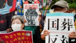 Para pengunjuk rasa berunjuk rasa menentang pemakaman kontroversial yang disponsori negara terhadap mantan Perdana Menteri Shinzo Abe, Selasa, 27 September 2022, di Tokyo. (AP/Christopher Jue)