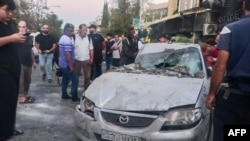 Emergency service personnel and residents gather at the site of an Israeli strike in Syria's capital Damascus on Oct. 2, 2024. 