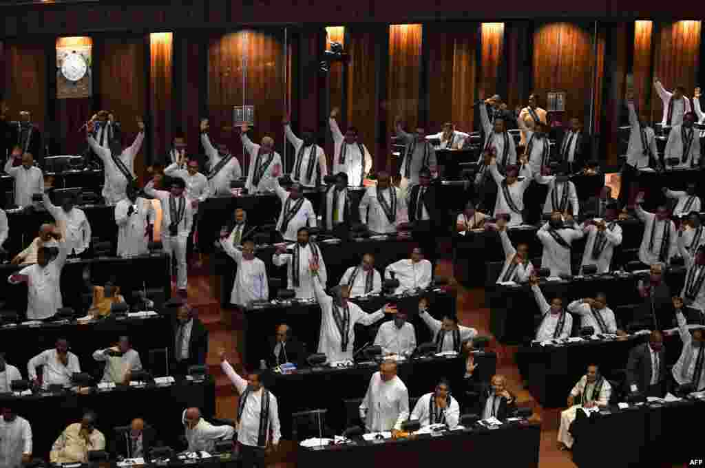 Members of the Sri Lankan parliament raise their hands at a session in Colombo. Sri Lanka's parliament passed a motion of no-confidence in the controversially appointed government of Mahinda Rajapakse a day after the Supreme Court overturned a presidential decree dissolving the legislature.