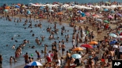People sunbathe on a beach in Barcelona, Spain, Wednesday, Aug. 1, 2018. (AP Photo/Manu Fernandez)