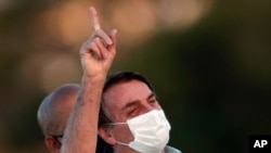 Brazil's President Jair Bolsonaro, who is infected with the novel coronavirus, wears a protective face mask as he attends a Brazilian flag retreat ceremony outside his official residence, the Alvorada Palace, in Brasilia, Brazil, July 22, 2020. 