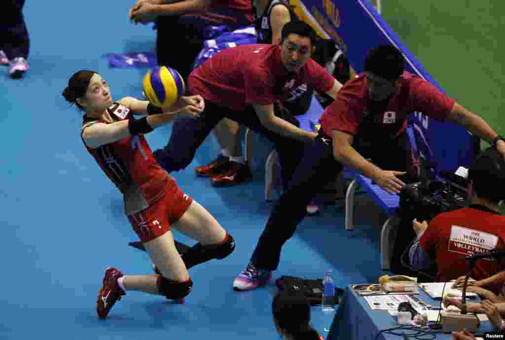 Japan's Arisa Sato (L) receives the ball to save a point against Brazil on the final day of the FIVB Women's Volleyball Grand Champions Cup 2013 in Tokyo, Japan.