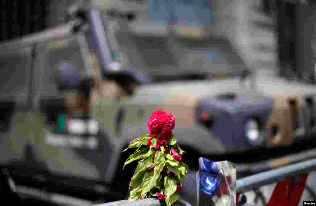 Flowers placed to pay tribute to the victims of the Bastille Day truck attack in Nice are seen in front of a military armoured vehicle at the French embassy in Rome, Italy, July 15, 2016.