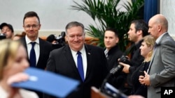 Menteri Luar Negeri Hongaria Peter Szijjarto (tengah) dan Mengeri Luar Negeri AS Mike Pompeo (tengah), tiba untuk menghadiri konferensi pers setelah pertemuan di Budapes, Hongaria, Senin, 11 Februari 2019.