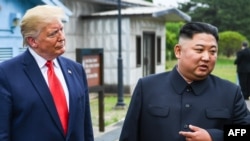 Pemimpin Korea Utara Kim Jong-un berbicara di samping Presiden AS Donald Trump di garis demarkasi yang memisahkan Korea Selatan dan Korea Utara, di Panmunjom, 30 Juni 2019. (Foto: AFP)