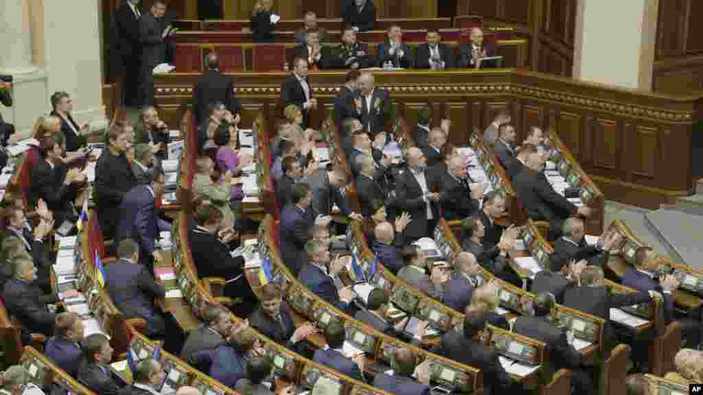 Ukrainian lawmakers applaud during a session of the parliament in Kyiv, Ukraine, Oct. 14, 2014.