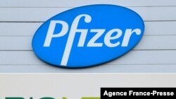 FILE - Combination of file photographs with the logo of Pfizer at the production site of the COVID-19 vaccine in Puurs, Belgium, and a logo of BioNTech at the headquarters of the company in Mainz, western Germany.