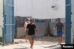 Ex soldados colombianos encarcelados por su presunta participación en el intento de asesinato del ex presidente de Haití Jovenel Moise caminan hacia los periodistas en la Penitenciaría Nacional, en Puerto Príncipe, Haití, 3 de marzo de 2024.