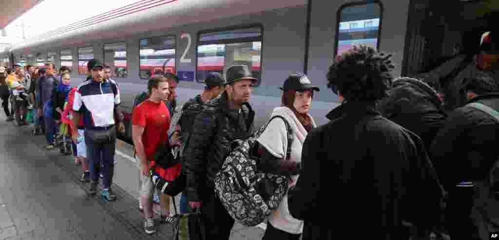 Migrants and refugees board a train from Vienna to Salzburg at the Westbahnhof train station in Vienna, Sept. 19, 2015.