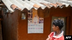FILE - A boy looks at a calendar with a portrait of India's Prime Minister Narendra Modi in Tatem village some 43 Km (27 miles) from Dantewada town in Chhattisgarh state on April 16, 2024.