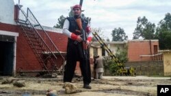 A Pakistani security officer stands on alert at the site of a bombing in Ghalanai in the Pakistan's tribal region of Mohmand, Feb. 15, 2017. 