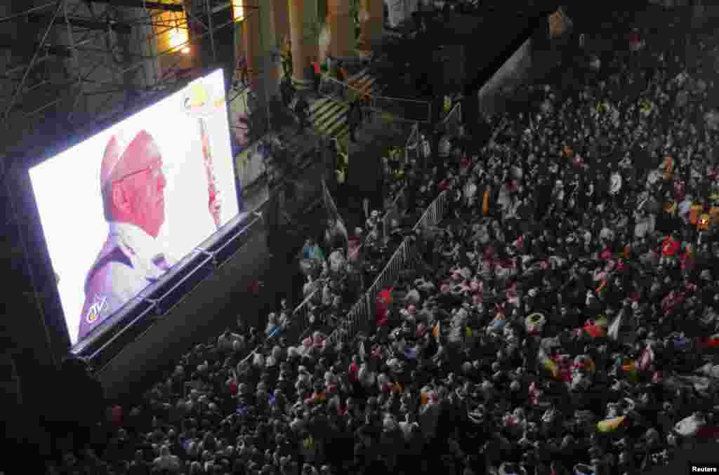 Umat Katolik yang taat mengikuti misa pentahbisan Paus Fransiskus yang ditayangkan melalui layar raksasa di Katedral Metropolitan di Buenos Aires, 19 Maret 2013.
