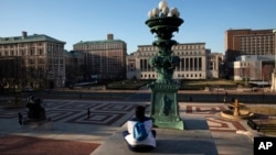 Seorang perempuan duduk di kampus Universitas Columbia, di New York, 9 Maret 2020. (Foto: AP)