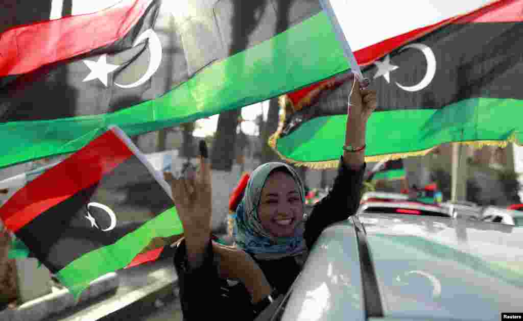 A woman celebrates on the streets in Tripoli's Martyrs' Square after casting her vote during Libya's National Assembly election, July 7, 2012.