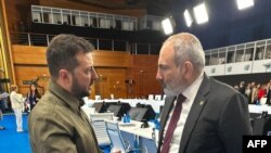 Ուկրաինայի նախագահի մամուլի ծառայության կողմից արված և հրապարակված լուսանկարում Եվրոպական քաղաքական համայնքի գագաթնաժողովի ժամանակ Ուկրաինայի նախագահ Վոլոդիմիր Զելենսկին զրուցում է Հայաստանի վարչապետ Նիկոլ Փաշինյանի հետ