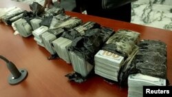 Mata uang dolar AS yang disita dari tiga warga negara China yang ditangkap di Kongo karena memiliki emas batangan dan $400.000, dipajang di dalam ruang sidang di Bukavu, Kongo, 4 Januari 2025.