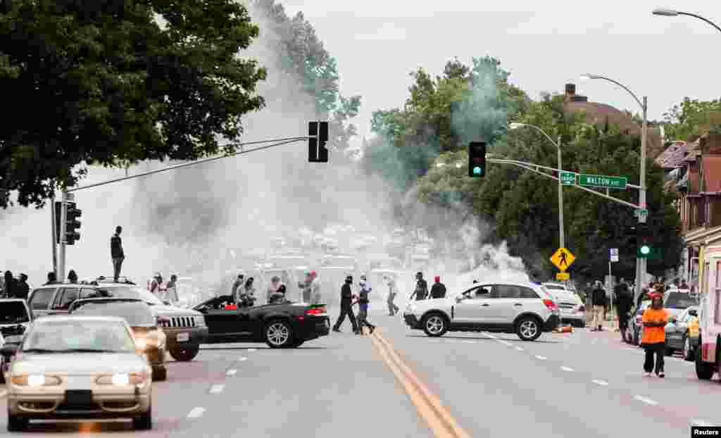 Tear gas rises as police attempt to disperse protesters on Page Avenue after a shooting incident in St. Louis, Aug. 19, 2015. 