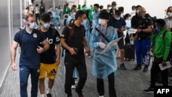 Three members of the Olympic refugee team, Ahmad Alikaj (L), Abdullah Sediqi (2nd L) and coach Alireza Nassrazadany (3rd L) arrive at Narita international airport in Narita, Chiba prefecture on July 14, 2021. (Photo by Kazuhiro NOGI / AFP)