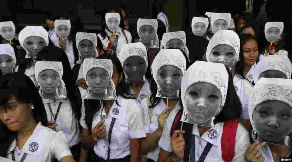 Para siswi Sekolah Putri Katolik, St. Scholastica College, di Manila, Filipina, menutup wajahnya dengan topeng yang menggambarkan para siswi yang diculik oleh militan Boko Haram di Afrika. Lebih dari 1.000 siswi ambil bagian dalam protes yang ditujukan untuk menyuarakan kemarahan atas penculikan lebih dari 200 siswi sekolah di Timur Laut Nigeria pada bulan April oleh kelompok militan itu. 
