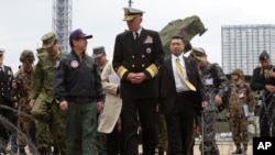 FILE - U.S. Adm. Samuel Locklear talks with Japanese Gen. Shigeru Iwasaki, front left, after inspecting Patriot missile units deployed in Tokyo, April 11, 2012.