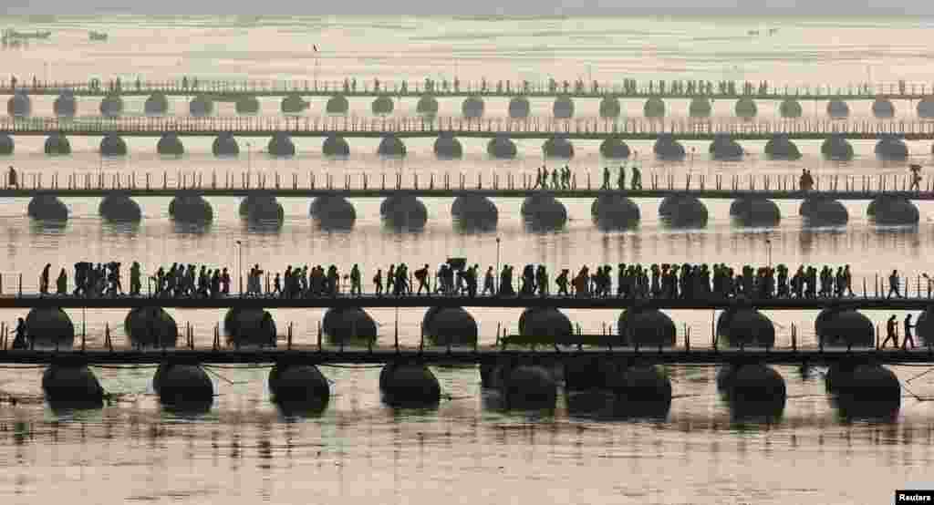 Hindu devotees cross pontoon bridges spanning the river Ganges during the first "Shahi Snan" (grand bath) at the ongoing "Kumbh Mela", or Pitcher Festival, in the northern Indian city of Allahabad, January 14, 2013.