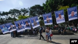 Sejumlah foto dari tahanan politik yang ditahan oleh pemerintah Nikaragua terpampang dalam sebuah protes yang dilakukan oleh para eksil Nikaragua di Guatemala pada 7 November 2021. Mereka memprotes pemilu yang dimenangkan kembali oleh Daniel Ortega. (Foto: AFP)
