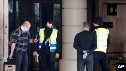 A coach delivers passengers to the Radisson Blu Edwardian Hotel, near Heathrow Airport, London, Feb. 15, 2021 where they will remain during a 10 day quarantine period after returning to England from one of 33 "red list" countries.