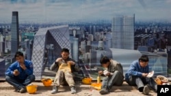 资料照：在北京中央商业区工地外围吃饭的中国建筑工人。