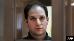 FILE - Jurnalis AS Evan Gershkovich, ditangkap atas tuduhan spionase, melihat keluar dari dalam kurungan terdakwa sebelum sidang untuk mempertimbangkan banding atas perpanjangan penahanan pra-sidang, di Pengadilan Kota Moskow, Rusia, 20 Februari 2024.