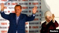 Turkey's Prime Minister Recep Tayyip Erdogan celebrates his election victory flanked by his wife Ermine in front of his party's headquarters in Ankara August 10, 2014.