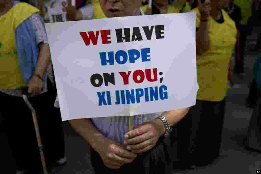 An exiled Tibetan man holds a banner during a protest to highlight Chinese control over Tibet, coinciding with the visit of Chinese President Xi Jinping in New Delhi, India, Sept. 17, 2014.