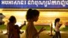 FILE - People walk using their mobiles phones in Phnom Penh, Cambodia, Feb. 18, 2021. The Cambodian government issued a sub-decree to establish a National Internet Gateway that would give it control over the flow of information on the internet.