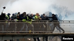 Polisi anti huru-hara Perancis bentrok dengan demonstran di jembatan Leopold-Sedar-Senghor, Paris, 5 Januari 2019 lali. 