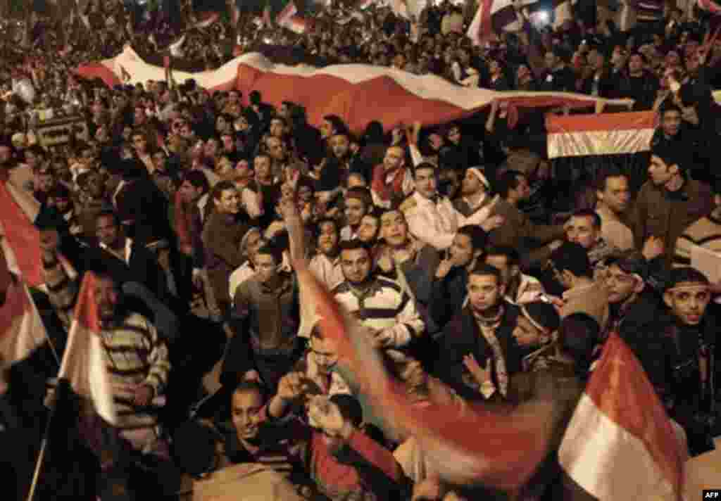Egyptian citizens wave a huge Egyptian flag as they celebrate after President Hosni Mubarak resigned and handed power to the military at Tahrir square, in Cairo, Egypt, Friday, Feb. 11, 2011. Egypt exploded with joy, tears, and relief after pro-democracy
