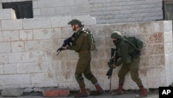 FILE - Israeli soldiers conduct a search for suspects of a shooting attack on Dec. 9, 2018, in the West Bank City of Ramallah, Dec. 10, 2018. 